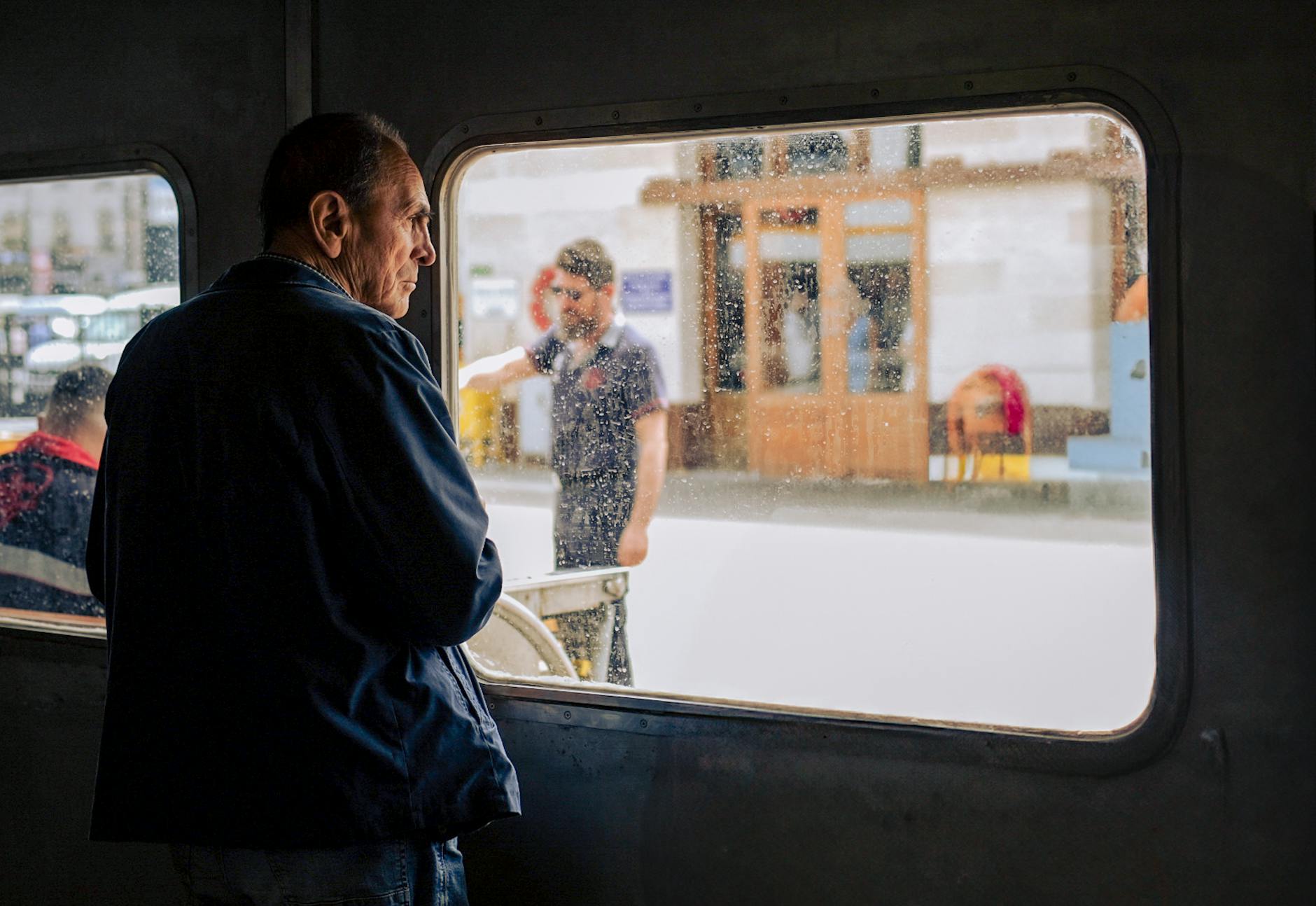 Budget Backpacker'S Guide: How To See The World On A Shoestring 1 adult man looking out a ferry window in i̇stanbul, capturing the city's bustling ambiance.