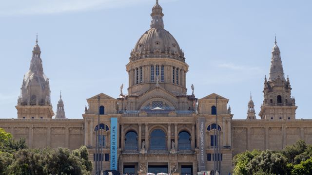 Spain, Front view of the National Art Museum of Catalonia showcasing its grand architecture under a clear sky.