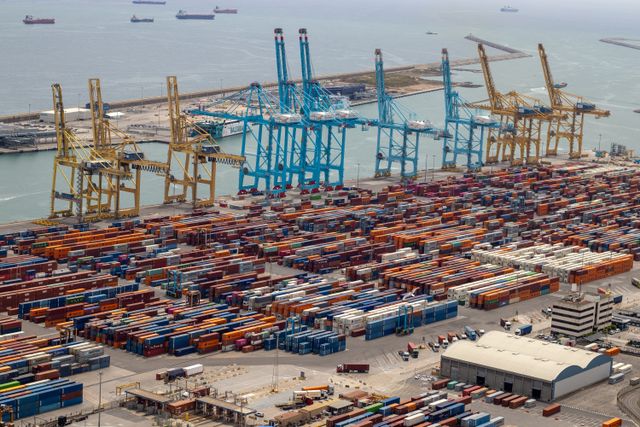 Busy international seaport with cranes loading export containers
