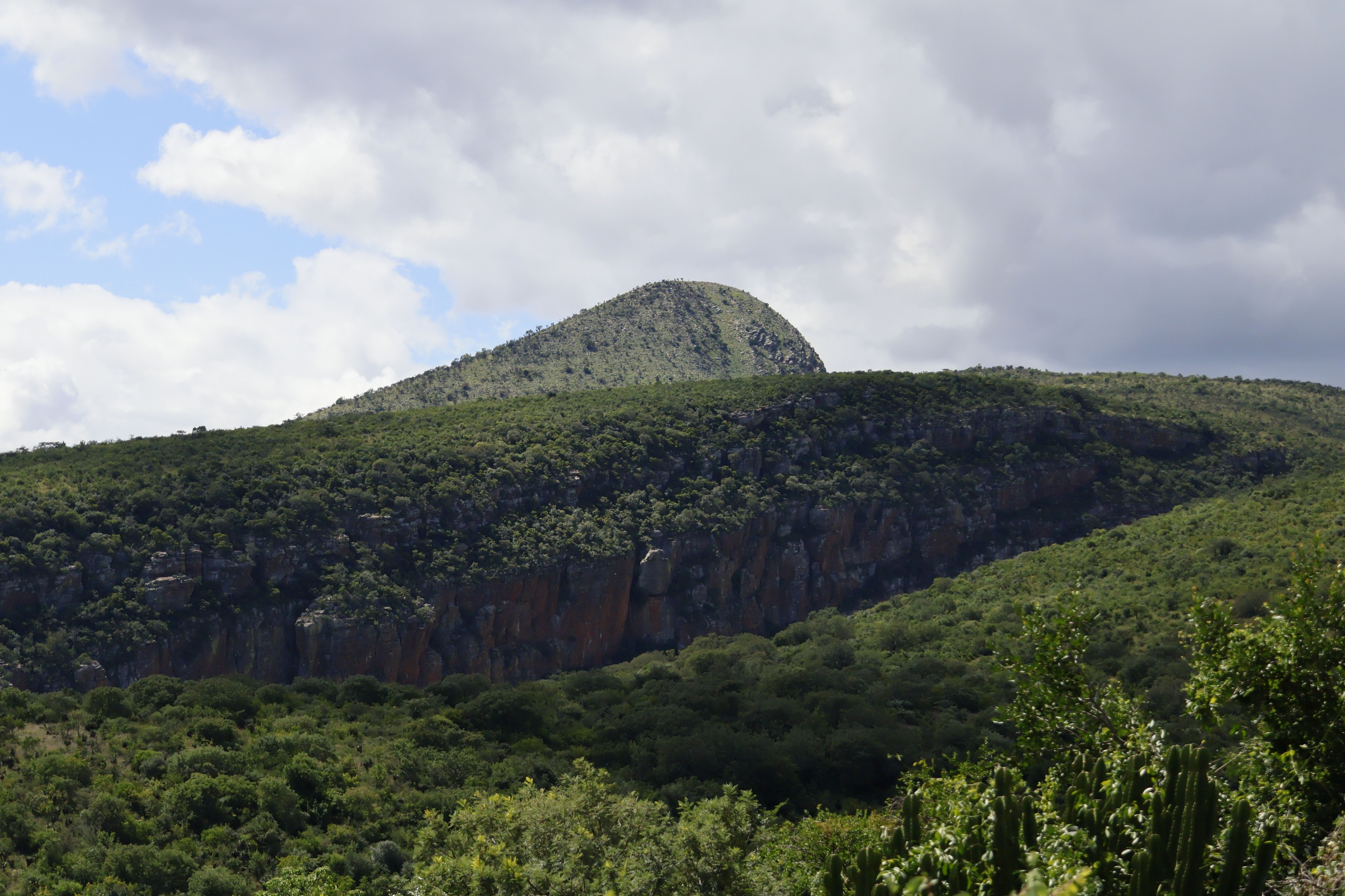 Lush Green Mountain Landscape Under Cloudy Sky · Free Stock Photo