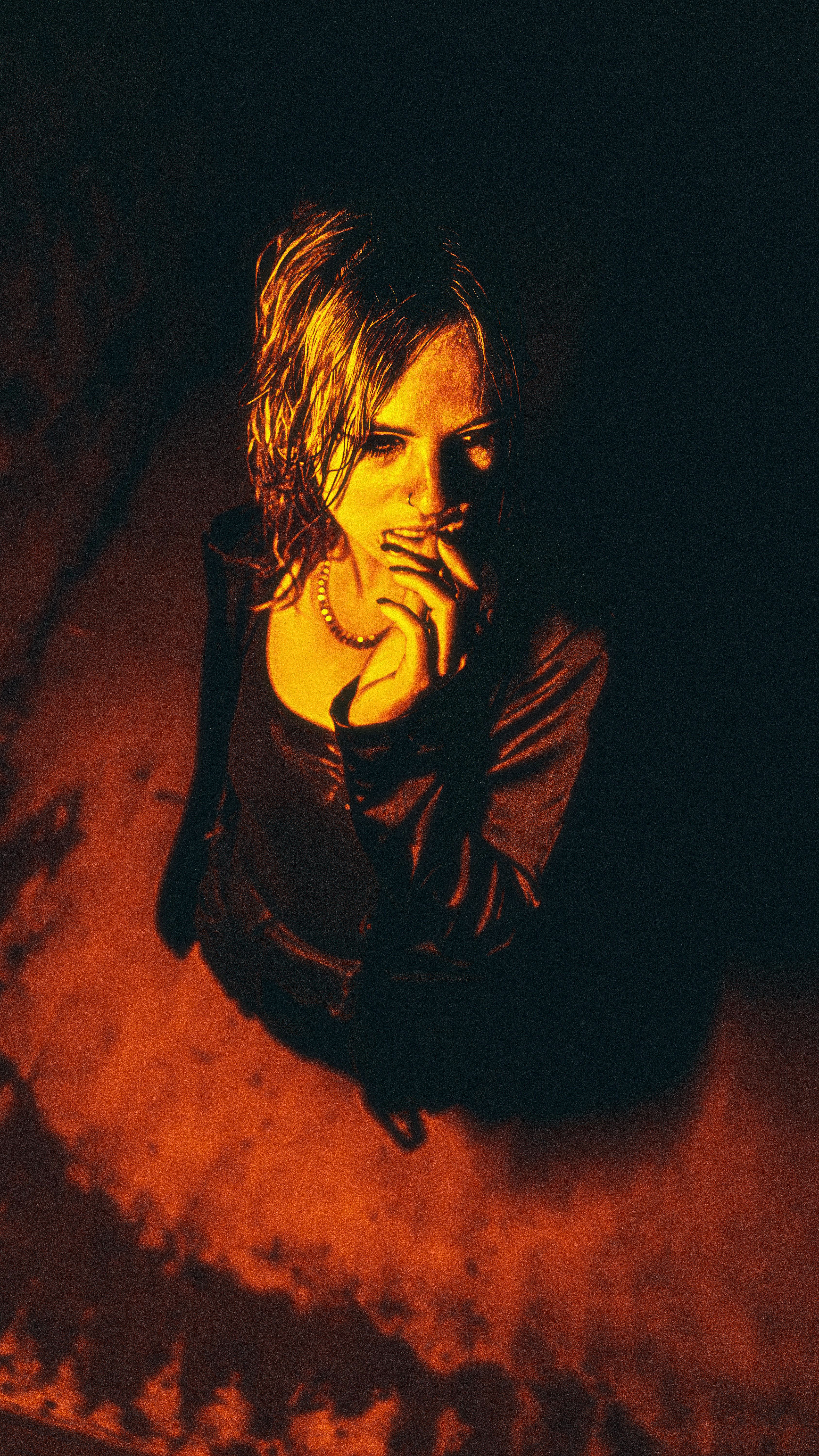 Portrait of a woman looking contemplative with dramatic lighting creating a mysterious atmosphere.