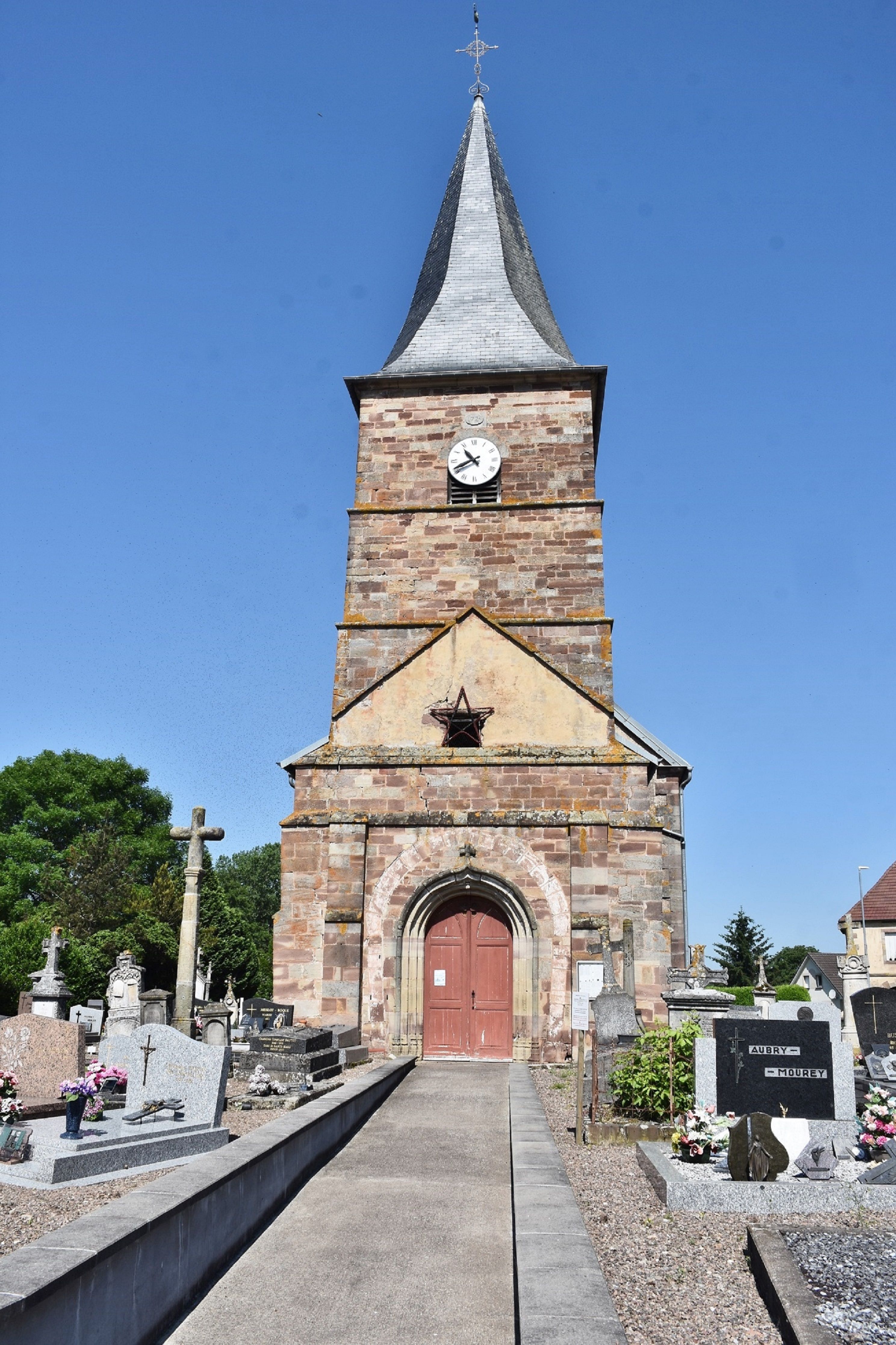 A detailed view of a historic church tower in Sainte-Marie-en-Chaux, France.