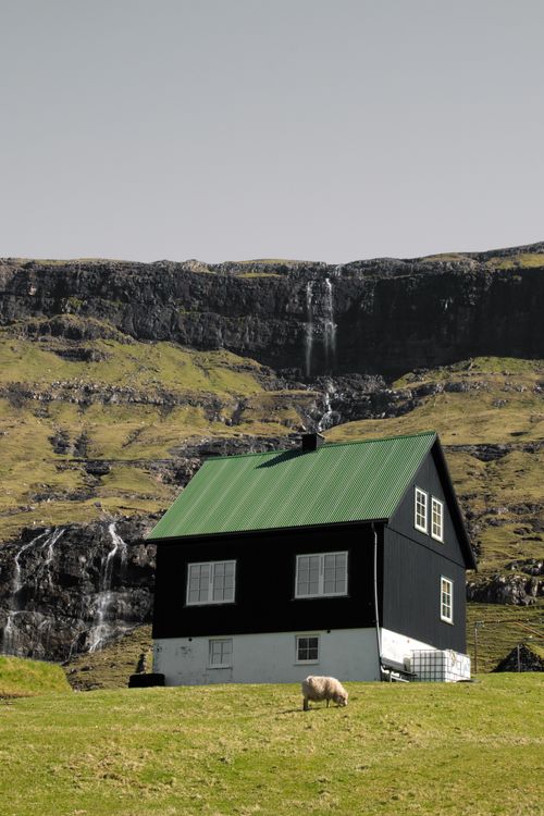 Free Beautiful secluded house in the Faroe Islands with a waterfall in the background. Stock Photo