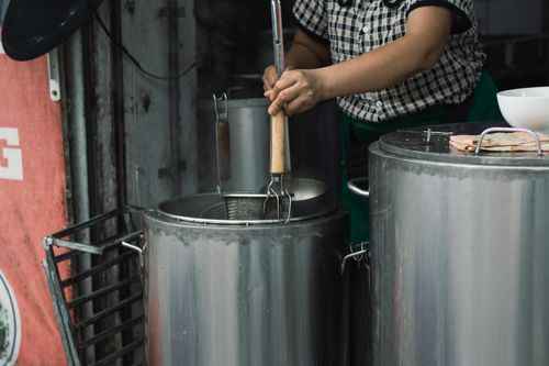 Free Street vendor preparing traditional Vietnamese noodles in Hanoi with stainless steel pots. Stock Photo