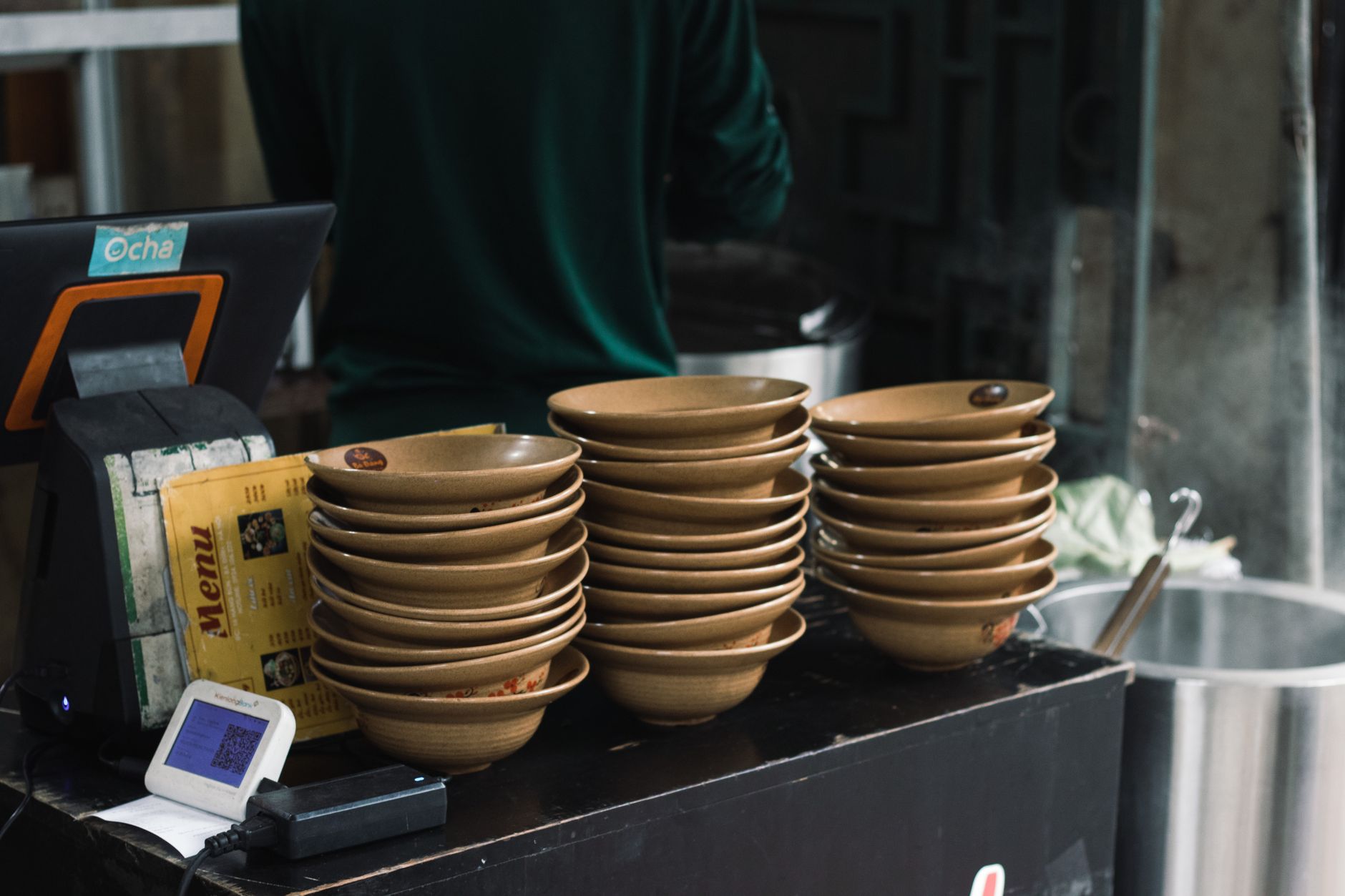 Stacked bowls at a street food stall in Hanoi, Vietnam, capturing local culinary atmosphere.