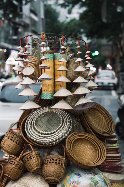 Free Colorful woven baskets and conical hats at a vibrant Hanoi street market. Stock Photo