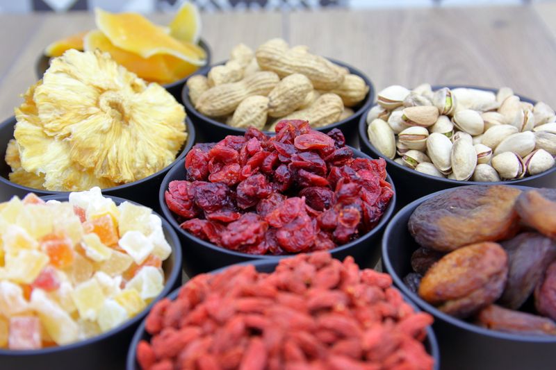 Bowls of mixed nuts and dried fruit on a wooden table — photo by Joel Camelot on Pexels