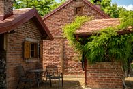 Cozy brick house with lush greenery in Dišnik, Croatia under a clear sky.