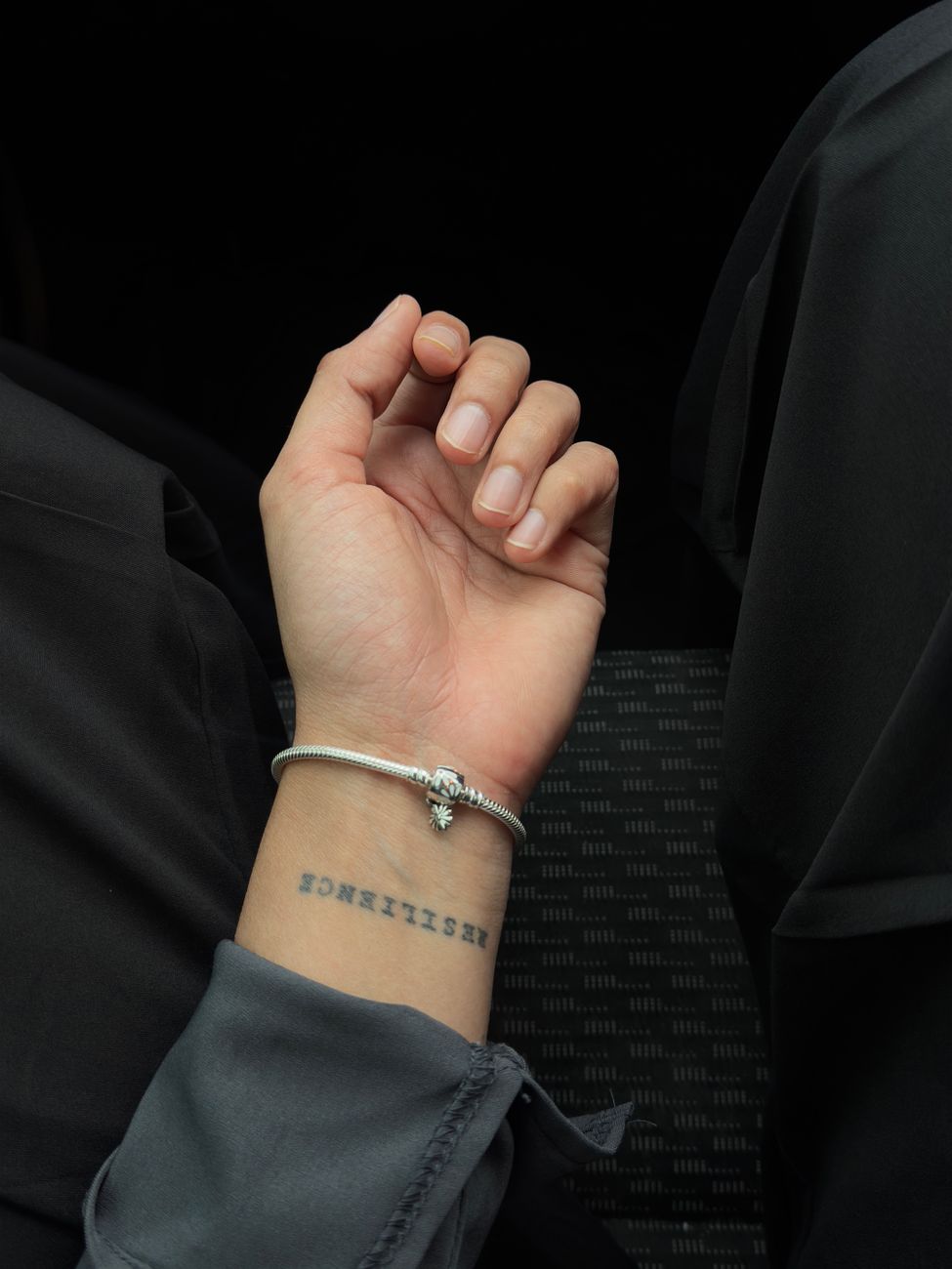Minimalist custom temporary tattoo design worn on the wrist with a bracelet, everyday lifestyle setting