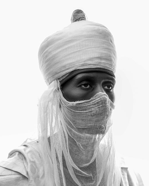A captivating black and white portrait of a person in traditional attire with a serene expression.