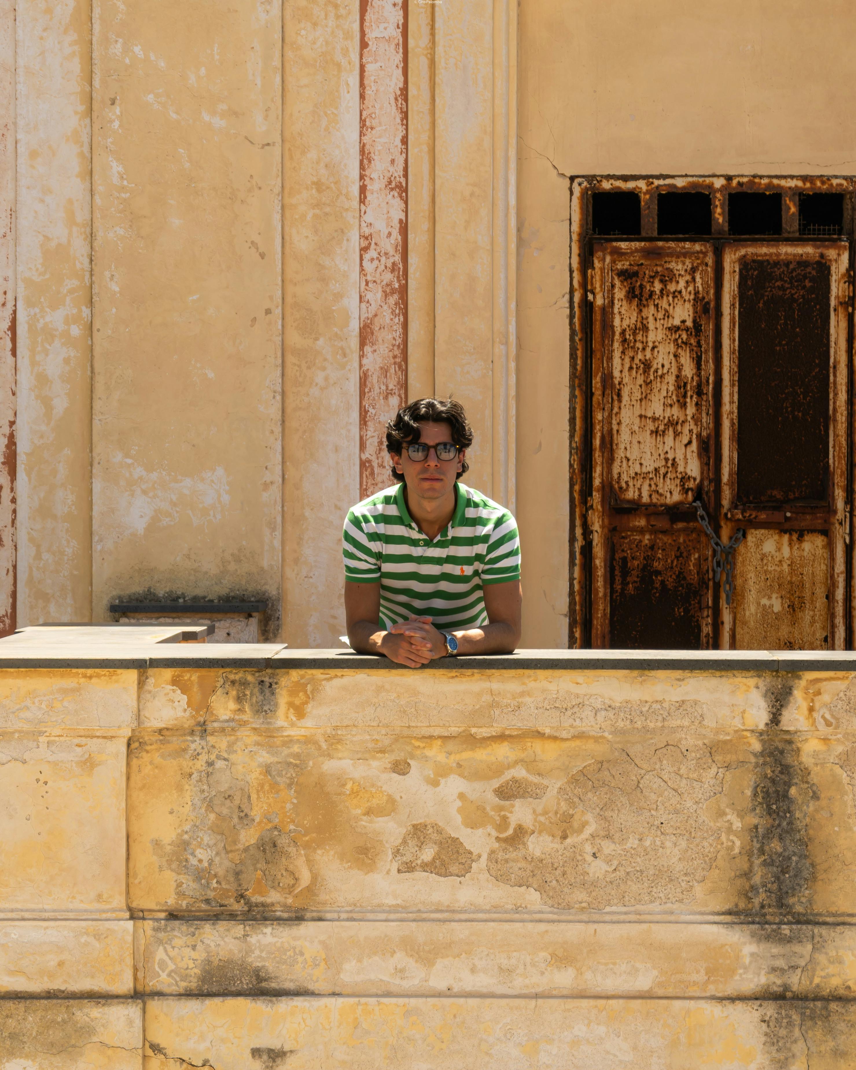 Free A man in sunglasses leans on a rustic wall in the summer sun, Napoli, Italy. Stock Photo