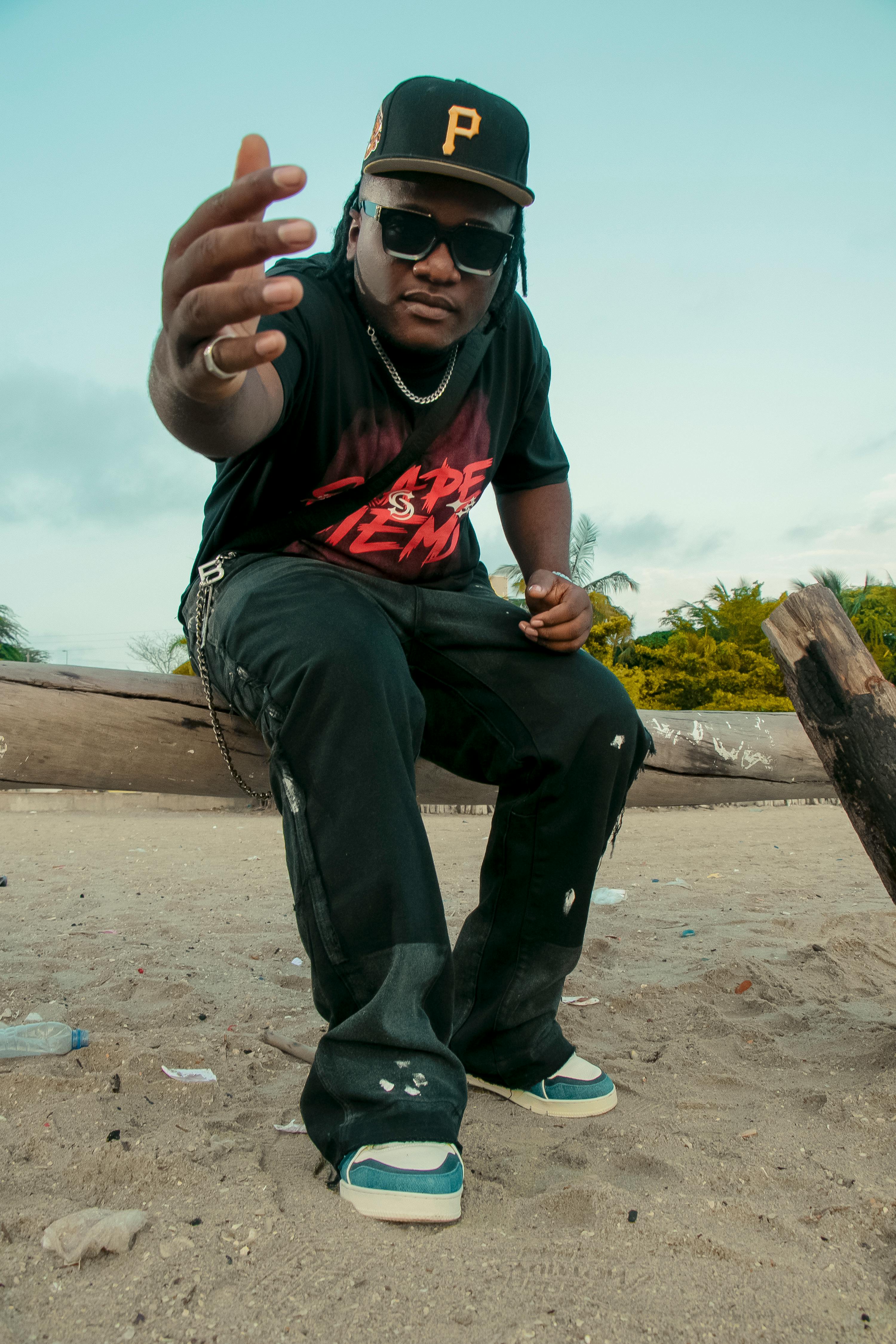 Dynamic portrait of a man on a sandy beach in Goa, India, wearing casual streetwear.