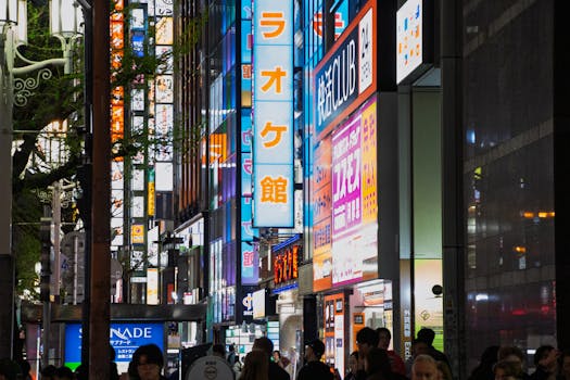 A colorful nighttime scene of Tokyo's lively streets with bright neon signs and a bustling crowd.