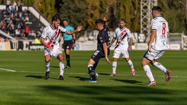 Intense soccer match showcasing skill and teamwork on a sunny outdoor field.