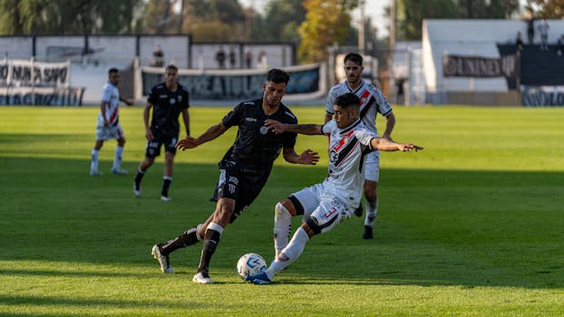 Dynamic moment from a thrilling soccer match captured in action on a vibrant green field during the day.