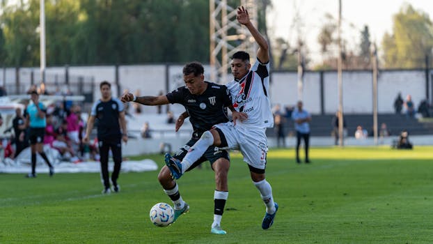 Dynamic shot capturing two footballers vying for the ball during an outdoor soccer match.