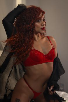 Elegant portrait of a woman in red lingerie, showcasing confidence and style.