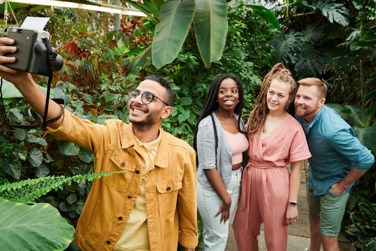 Photo Of People Talking Selfie Using Instant Camera