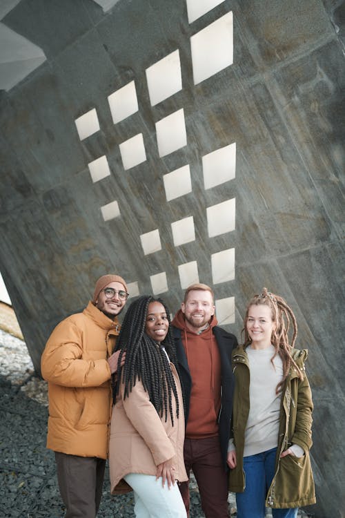 Group Of People Standing Beside Gray Concrete Wall