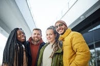 一群年轻人在城市户外环境中微笑，展现了多元化的友谊与团结