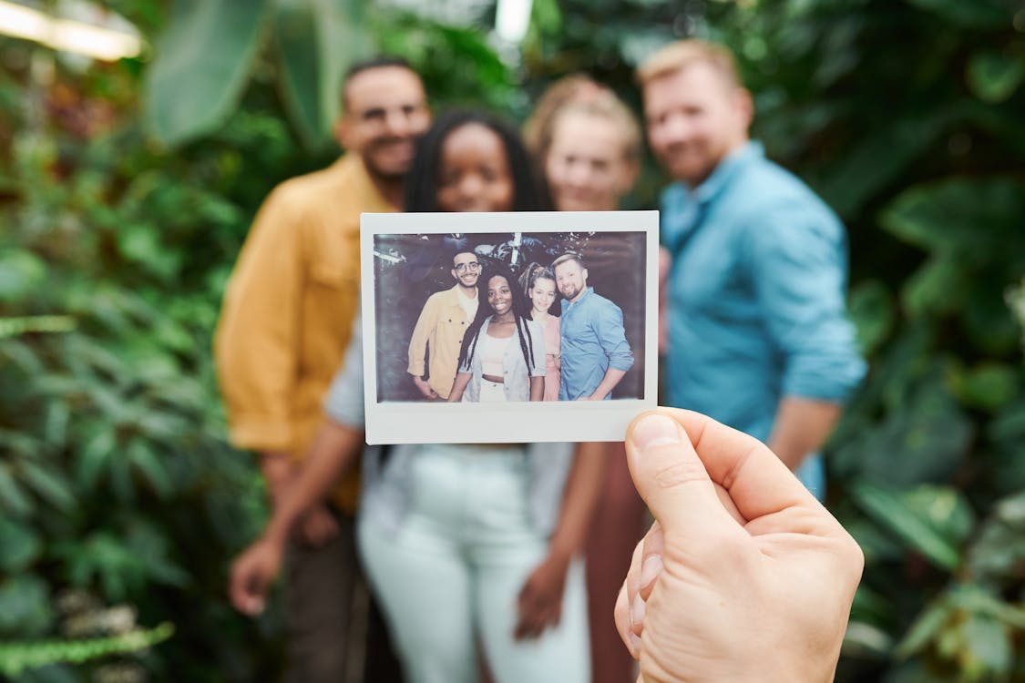 Shallow Focus Photo of Person's Hand Holding a Picture