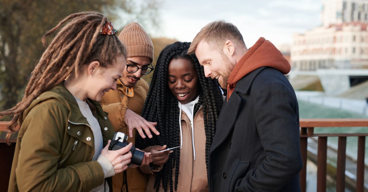 Friends sharing a moment outdoors in winter attire, smiling and happy.