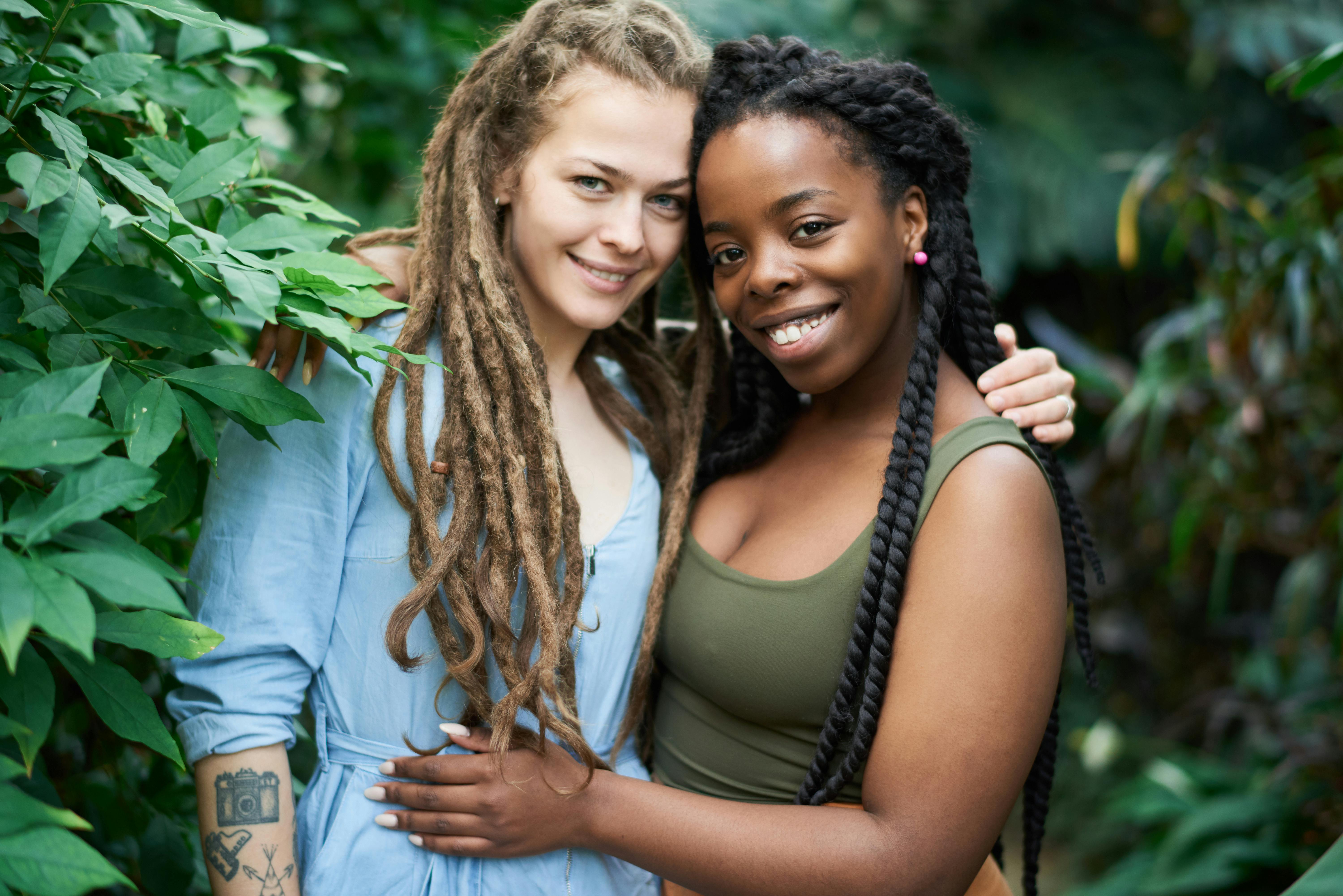 photo of women standing near leaves