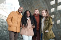 四个穿着冬装的朋友在户外微笑，享受在一起的时光