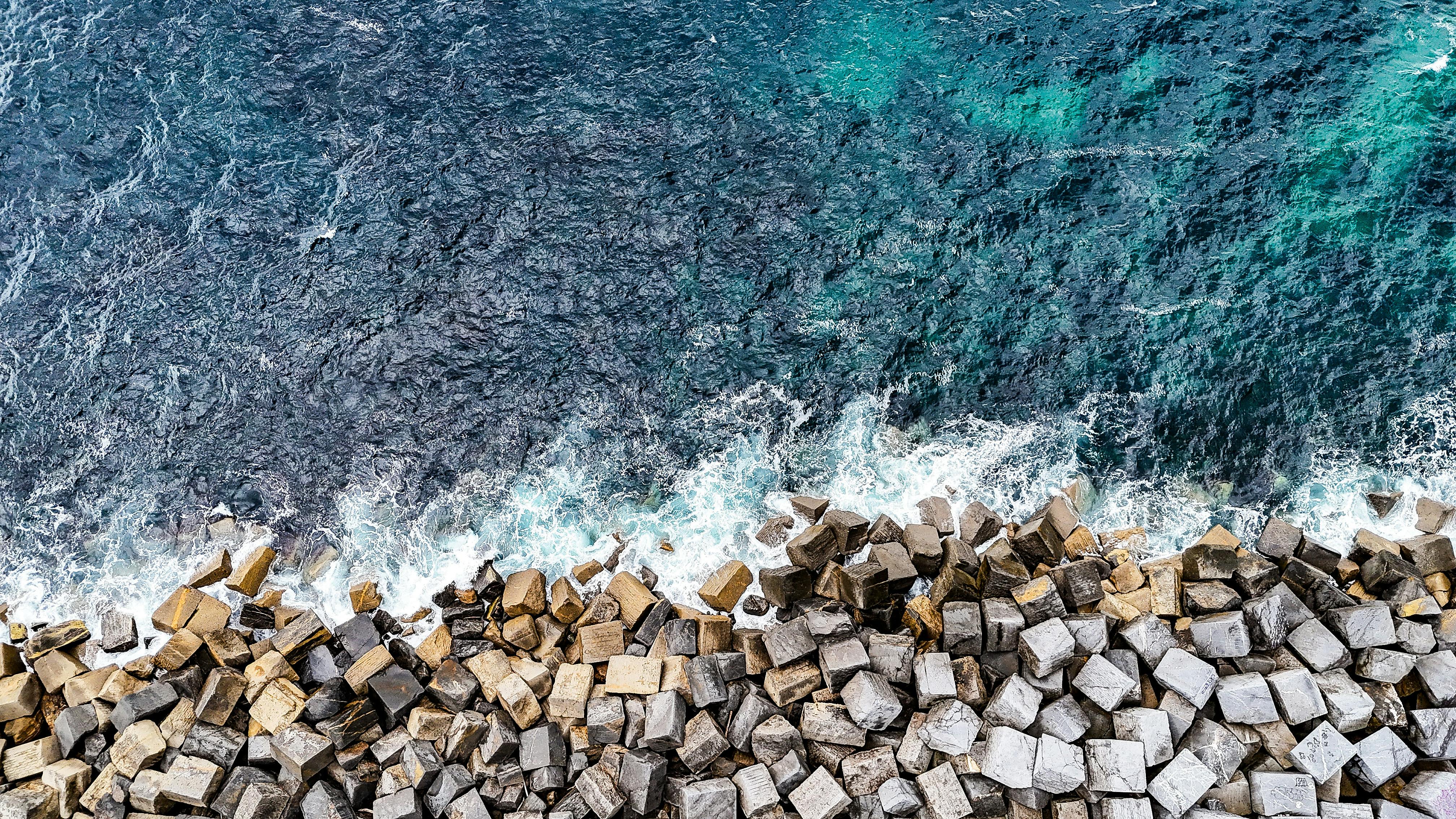 Aerial view of coastal breakwaters and ocean waves in Donostia-San Sebastian, Spain.