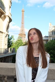 Stylish woman poses outdoors with Eiffel Tower view, embracing a modern Parisian vibe.