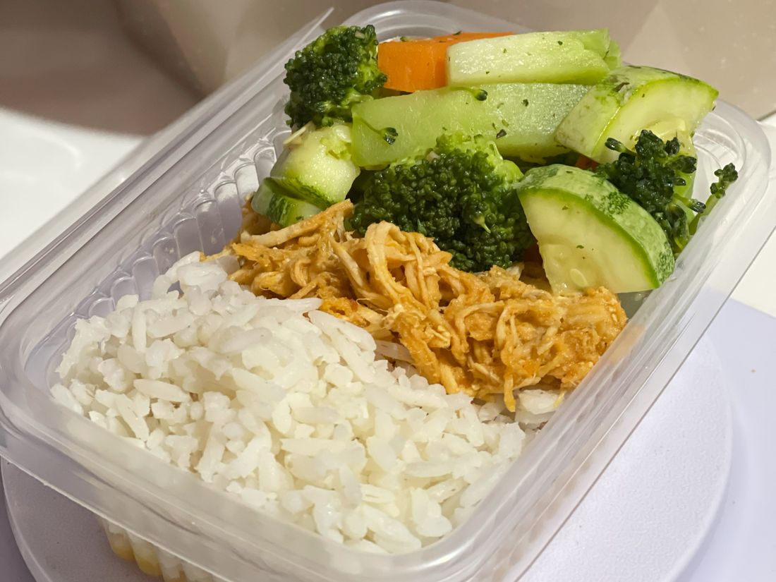 Plat à emporter avec riz, poulet et légumes, photo d’illustration