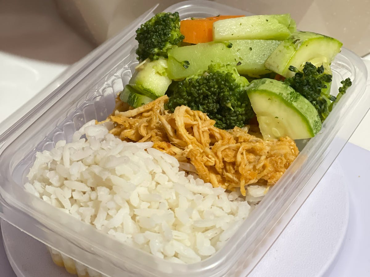 Nutritious meal prep box with rice, shredded chicken, and mixed vegetables