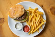 白色盘子里装着令人垂涎的奶酪汉堡和酥脆的薯条，非常适合快餐爱好者