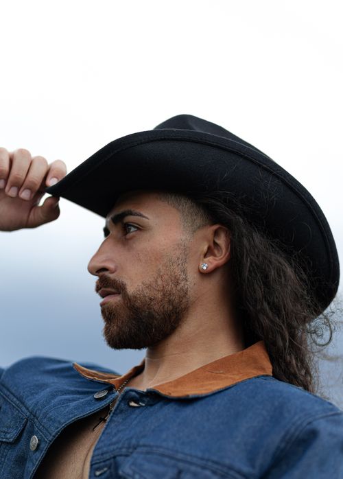 Free Portrait of a man in a cowboy hat looking into the distance. Stock Photo