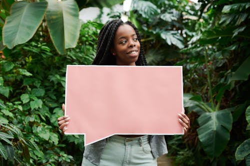 Photo of Woman Smiling While Holding a Blank Signboard