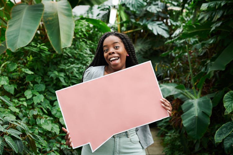 Photo Of Woman Smiling While Holding Blank Signboard