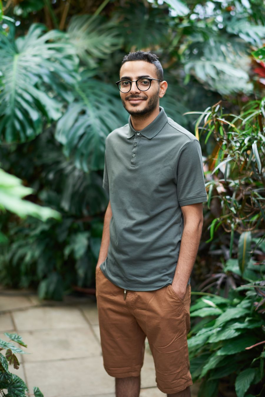 Person standing in a lush indoor garden, photo by fauxels on Pexels