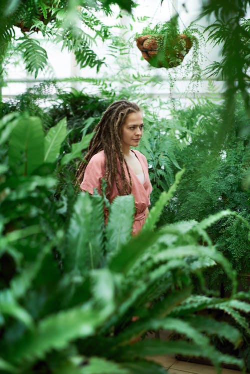 女人站在植物之間的選擇性焦點攝影