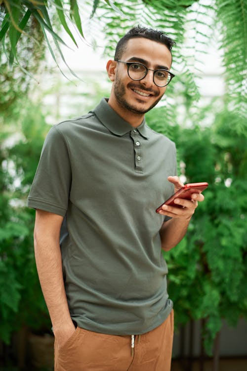 Free Man in Gray Polo Shirt Holding Red Smartphone Stock Photo