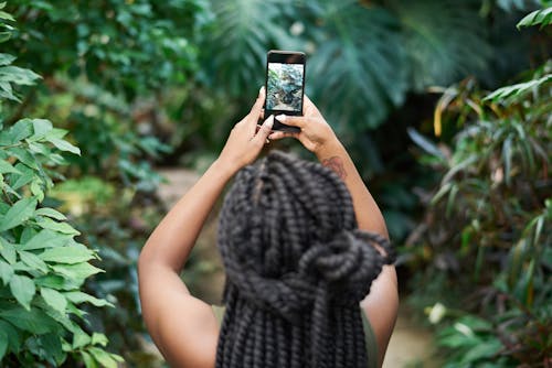 免费 女人抱着黑色的智能手机 素材图片