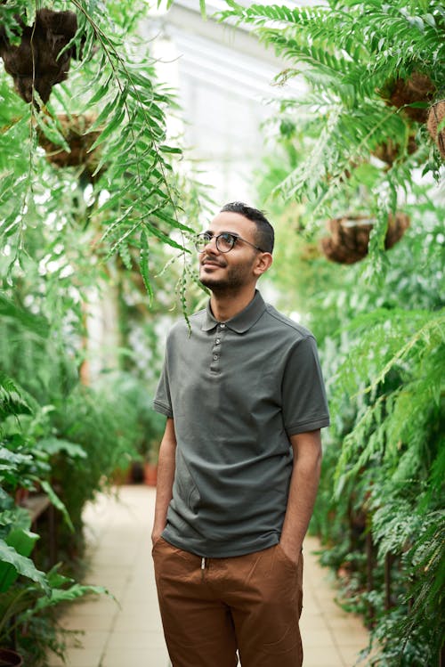 Photo D'un Homme Debout Près De Plantes à Feuilles Vertes