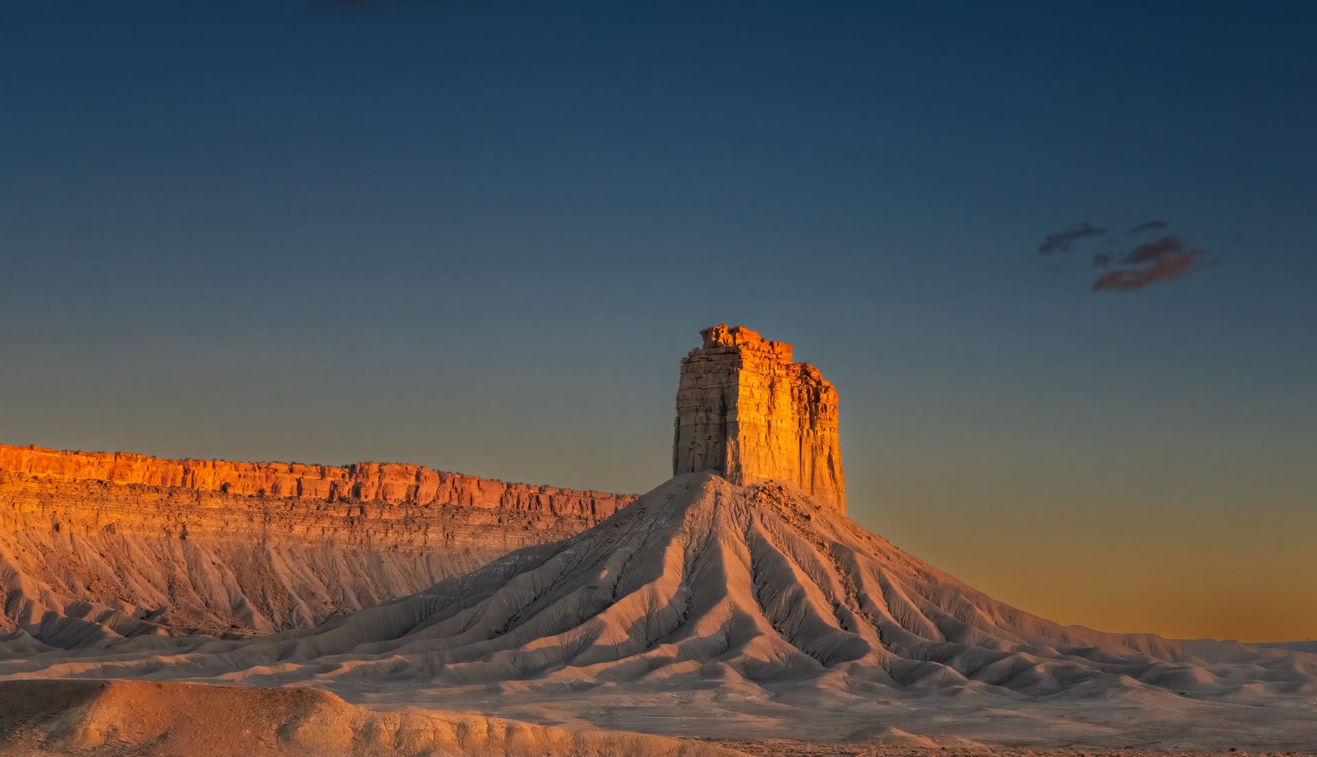 Golden light hits the mesa in Towaoc, Colorado at sunrise, showcasing dramatic geological features.