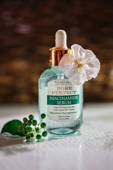 Pore Perfect Niacinamide Serum bottle with flowers and berries for skincare promotion.