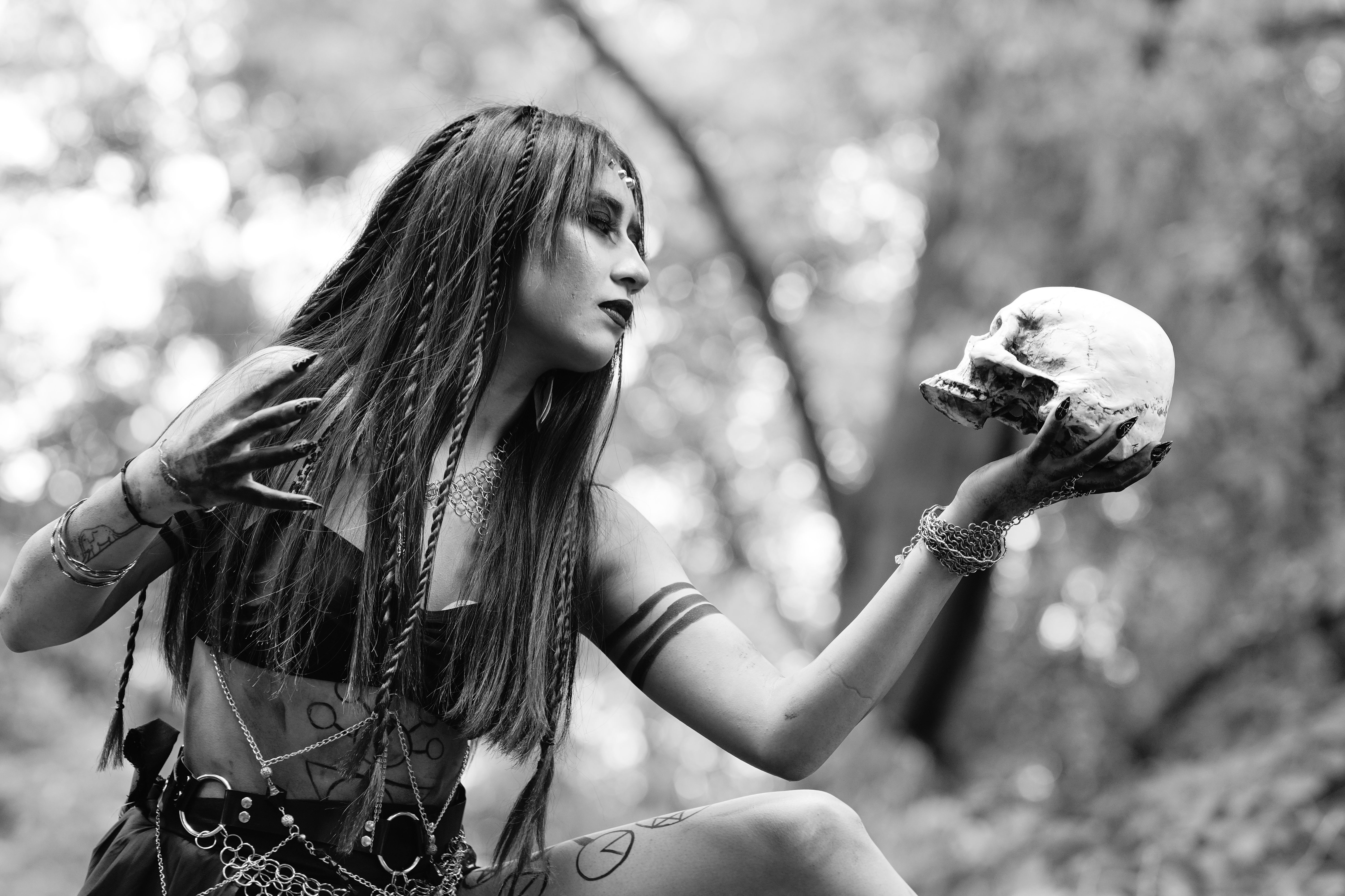 Black and white photo of a woman holding a skull, creating a mysterious and gothic atmosphere.