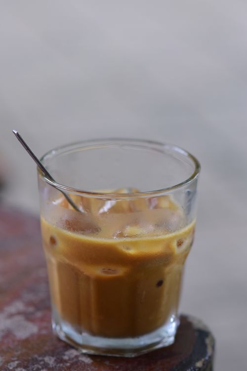 Free Close-up of a refreshing iced coffee in a glass with a silver spoon on a wooden table. Stock Photo