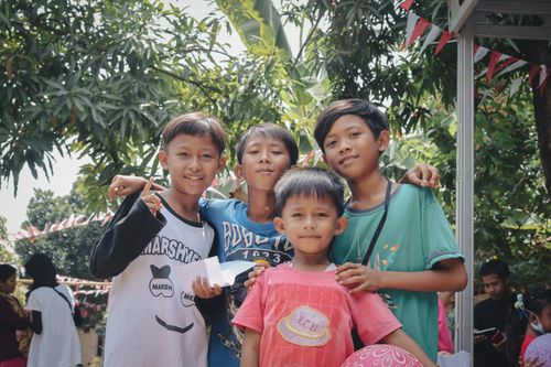 Free Group of smiling Indonesian children in Cirebon showing happiness and togetherness outdoors. Stock Photo