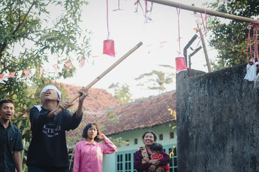 Children in Cirebon enjoy a traditional game during an outdoor festive event.