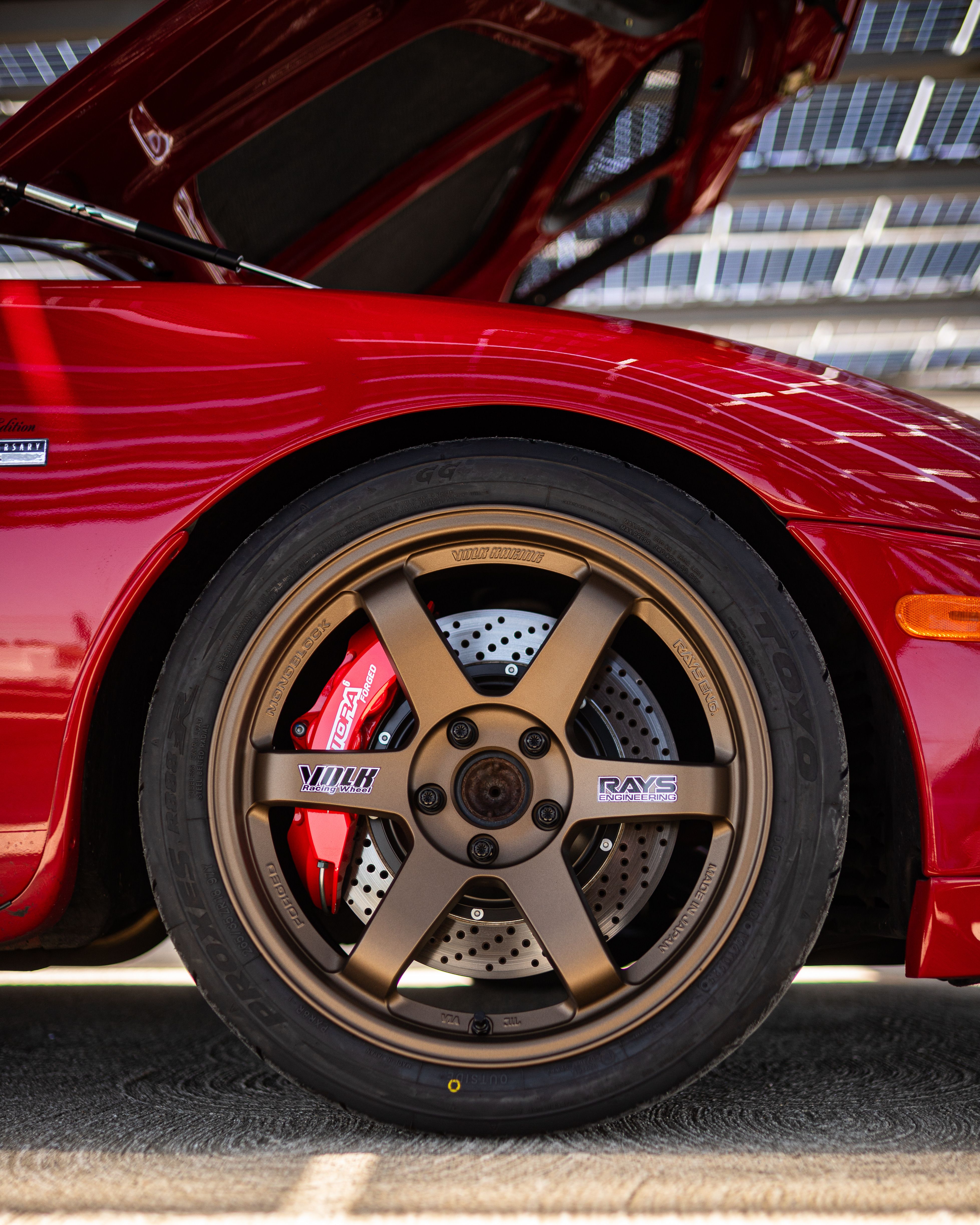 Close-Up of Red Car with Bronze Wheel and Open Hood · Free Stock Photo