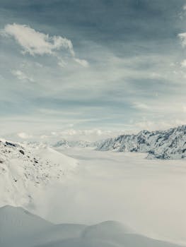 Majestic view of the snowy Swiss Alps with dramatic sky and vast snowfield.