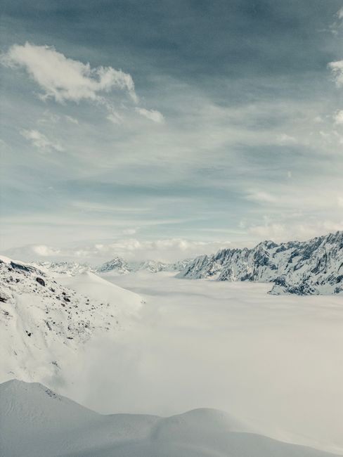 Majestic view of the snowy Swiss Alps with dramatic sky and vast snowfield.